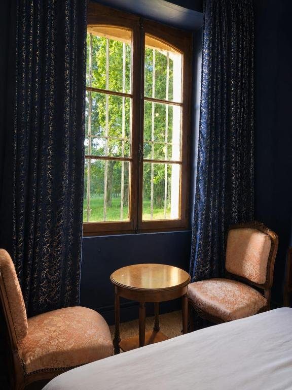Chambre Bleu Nuit — fauteuils et guéridon devant la fenêtre ouvrant sur le parc