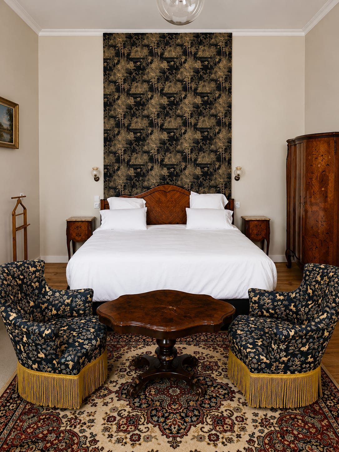 La Grande Chambre Verte — le lit ancien en bois sous son panneau botanique, encadré des fauteuils à franges dorées