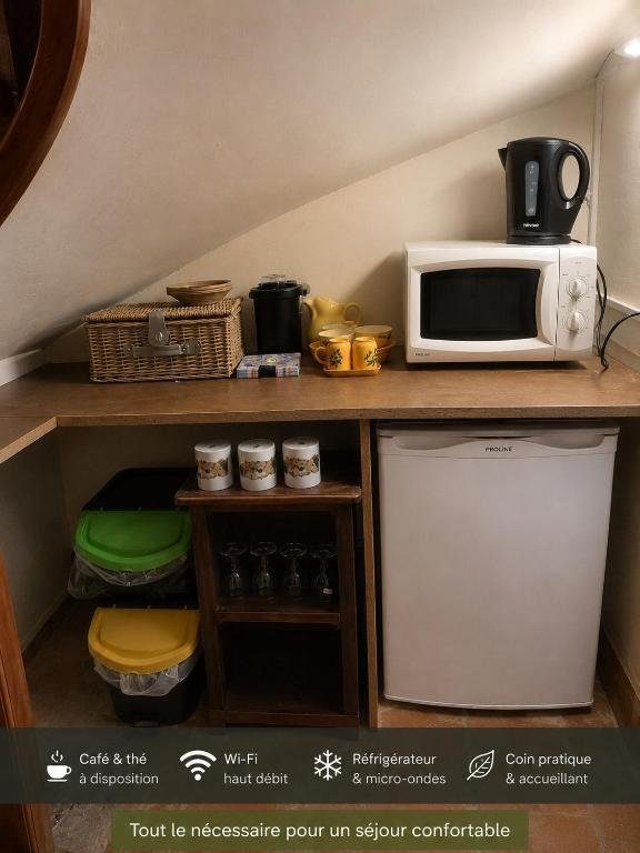 La kitchenette partagée — bouilloire, micro-ondes, réfrigérateur, verres à vin et panier pique-nique